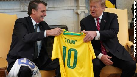 ژایر بولسونارو، رئیس جمهور برزیل، پیراهن تیم ملی برزیل را در 19 مارس 2019 در کاخ سفید در واشنگتن دی سی، رئیس جمهور ایالات متحده، دونالد ترامپ، هدیه می دهد.