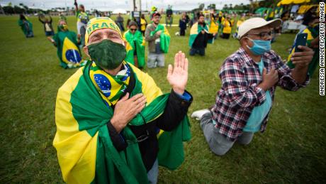 حامیان رئیس جمهور برزیل، ژایر بولسونارو، در طول یک کاروان راهپیمایی و اعتراض به کنگره ملی و دادگاه عالی به دلیل اقدامات قرنطینه در بحبوحه همه گیر کروناویروس (COVID-19) در مقابل کنگره ملی در 09 مه 2020 در برازیلیا اعتراض می کنند.
